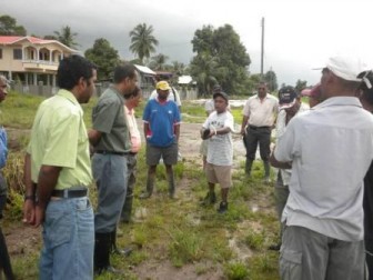 Agriculture Minister, Robert Persaud (second from left) in discussion with West Demerara residents on the flooding problems affecting them. (GINA photo) 