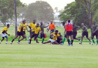 Yamaha Caribs Claudius Butts is brought down by a GDF defender during their clash in the GRFU’s Men’s 15-a-side tournament yesterday at the National Park (Orlando Charles Photo)
