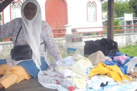 Clothes vendor Claudia Braithwaite sits on her stall at the market square at Central Mahaicony last week.