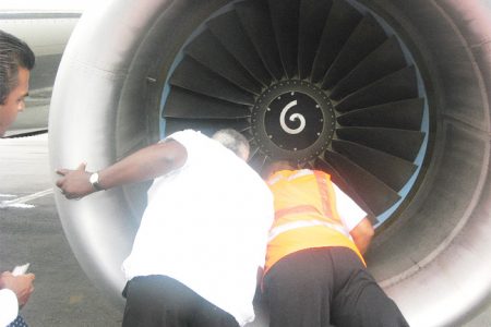 Minister of Transport and Hydraulics, Robeson Benn (left) inspecting the damaged engine. (GINA photo)