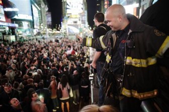 A firefighter waves to the crowd as people celebrate after Al Qaeda leader Osama bin Laden was killed in Pakistan, during a spontaneous celebration in New York's Times Square, May 2, 2011. REUTERS/Chip East