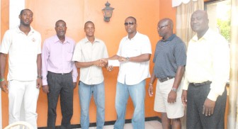 Carey Griffith (third from right) hands over the donation to Guyana’s captain Steve Neil Jr.