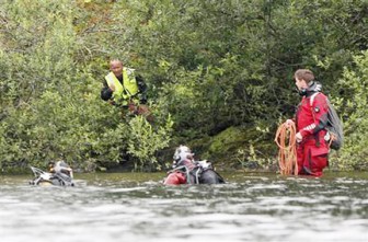 Divers search for bodies on the shore of the small, wooded island of Utoeya yesterday. (REUTERS/Truls Brekke)