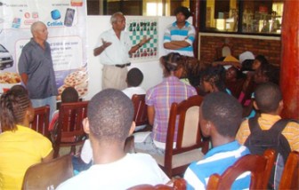 Chess Trainer Alex Joseph, Secretary Vishnu Rampersaud and National champion Taffin Khan and participants at yesterday’s Workshop.