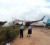 Two police officers stand near Caribbean Airlines’ US$38 million Boeing 737-800 plane as it lies across the road at Timehri after  skidding off the main runway yesterday morning. 