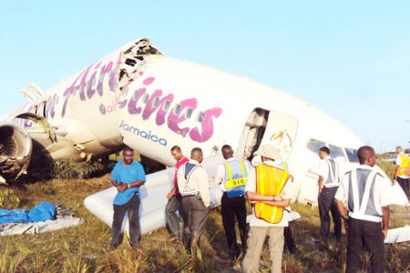 Aviation personnel and others swarm the wreckage. An inflated chute can be seen in the background.