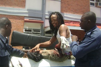 The shot Dwayne Critchlow being escorted from the police van to the Accident and Emergency Unit of the Georgetown Public Hospital.