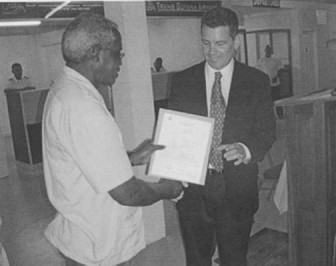 OAI Chairman Michael Correia receiving the Airport’s international certification from Minister of Works Robeson Benn