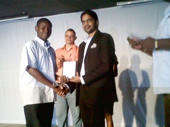 Terron Alleyne receives his award from GT&T CEO Yog Mahadeo