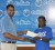 MILLION DOLLAR SMILE! GT&T’s Auditor, Sachin Persaud, hands over the first place cheque of one million dollars to Roxanne Keith, committee member of FastBall champions Pele Football Club.