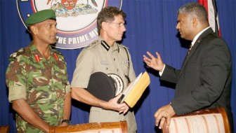 Attorney General Anand Ramlogan, right, talks with Police Commissioner Dwayne Gibbs, centre, and Chief of Defence Staff Brigadier Kenrick Maraj at the national security briefing and post-Cabinet news conference at the Diplomatic Centre, St Clair, yesterday. (Trinidad Guardian photo) 