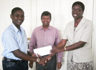 Terron Alleyne (left) receives his cheque from Deputy Permanent Secretary in the Education Ministry, Delma Nedd. Education Minister Shaik Baksh looks on.