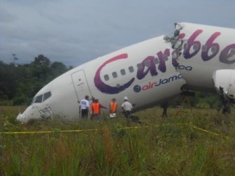 A NTSB investigator along with local officials inspecting the Caribbean Airlines plane yesterday.