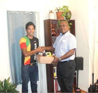 Geron Williams (left) receives his tyres, cassettes and chain from secretary of the GCANA, Gavin Lowman.