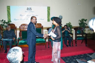 Myriam Chancy (right) as she shakes President Bharrat Jagdeo’s hand after receiving her award for her book ‘The Loneliness of Angels,’ which won her the 2010 Guyana Prize for Literature Caribbean Award in the Fiction category. (Anjuli Persaud photo)