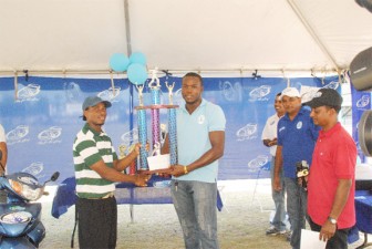  Captain of the GT Pitbulls team Oslyn Batson receives the winners’ cheque and trophy from Orlando Jones. (Aubrey Crawford photos)