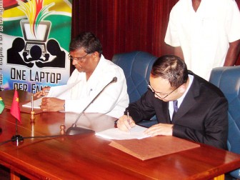 Office of the President Permanent Secretary Dr Nanda Gopaul (left) and Haier’s Sun Yongle signing the US$ 7.5 million contract yesterday.