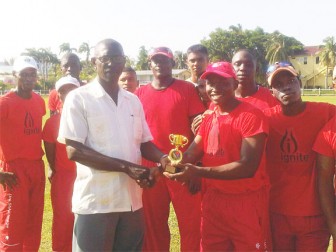 Competition coordinator Linden Matthews presents MVP trophy to Trevor Benn of Headquarters at Police Sports Club Ground, Eve Leary, Yesterday.