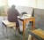 Having no chair a teacher sits on a desk to mark the daily register at the Golden Grove Secondary School on the first day of the term. (SN file photo) 