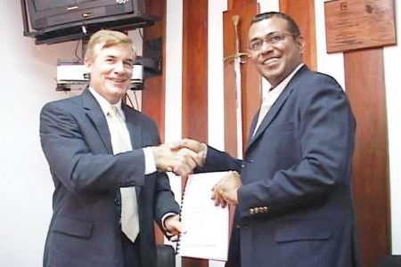 Agriculture Minister, Robert Persaud (right) receives the report from newly appointed US Ambassador Brent Hardt (GINA photo)