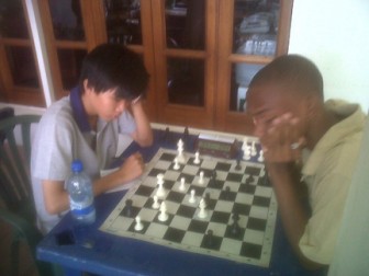 New junior chess champion Suhai Feng, left, in his final round clash against Anthony Drayton. Feng has the white pieces. (Emmerson Campbell photo)