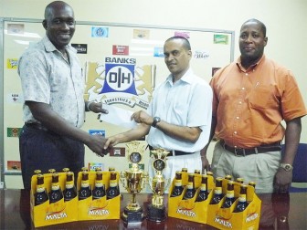 Guyana Chess Federation president Shiv Nandalall, second right, receives the sponsorship cheque from Clayton Mc Kenzie of Banks DIH Limited on Friday at Thirst Park. At right is Mortimer Stewart.