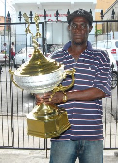 Organising Secretary of the Guyana National Dominoes Association (GNDA) Mark ‘Jumbie’ Wiltshire displays the first place trophy.