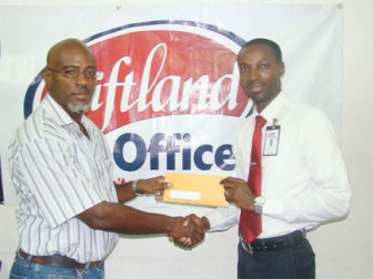 Team Manager Michael Harding (left) receives a sponsorship cheque from Giftland Office Max’s Marketing Manager Compton Babb.