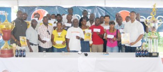 Representatives of the 18  participating local teams pose with the Tournament Booklets and cheques. (Orlando Charles Photo)