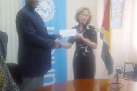 UNICEF Representative Dr. Suleiman Braimoh (left) presents the $3M cheque to Director of the Guyana Legal Aid Clinic Josephine Whitehead. 