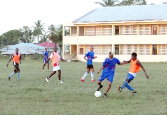 Two players tussle for the ball during the practice game between Milerock FC and Netrockers FC at the Wisburg School recently. (Orlando Charles Photo)