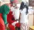 Santa and his helper coaxed this little girl to tell them what she would like for Christmas when Electronics City of Sheriff Street Subryanville gave gifts and food to orphans yesterday. (Photo by Anjuli Persaud)