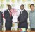 Giftland Officemax’s Marketing Manager Campton Bobb (second left) and GFF President Franklin Wilson (ag) display the contract while CEO of Giftland Officemax CEO Eon Ramdeo (left) and GFF General Secretary Noel Adonis (right) look on.