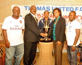 Cathy Hughes (second from right) shakes hands with Thomas United President Oliver Hinckson (second from left) after handing over the tournament trophy while Gerald Whittington (left), Ronald Lee-Bing (centre) and Winners’ Connection Secretary/Treasurer Haslyn Crawford look on. (Aubrey Crawford photo) 