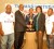 Cathy Hughes (second from right) shakes hands with Thomas United President Oliver Hinckson (second from left) after handing over the tournament trophy while Gerald Whittington (left), Ronald Lee-Bing (centre) and Winners’ Connection Secretary/Treasurer Haslyn Crawford look on. (Aubrey Crawford photo) 