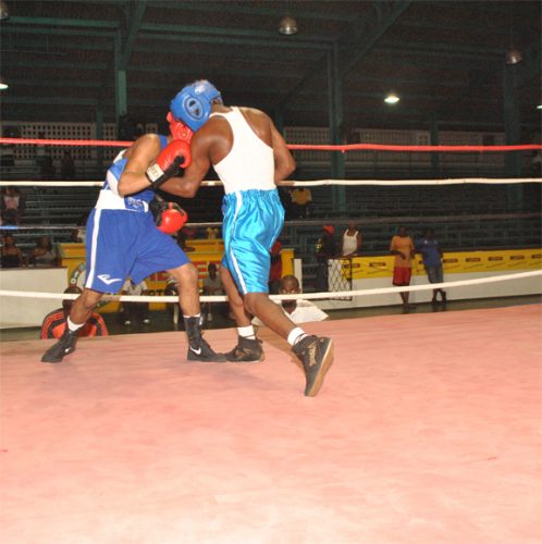 Richard Williamson, right, connects a left hand to the body of USA based Lawrence Singh in their flyweight bout on Saturday night at the Guyana Amateur Boxing Association (GABA) National Trials Championships. Aubrey Crawford photo