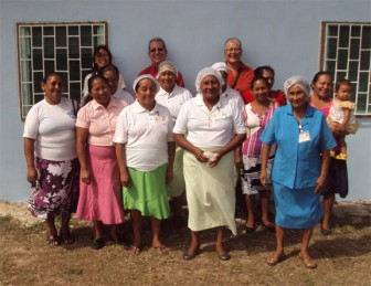 Members of the Helping Hands Women’s Group pose with (centre, back row) Head of Aid at CIDA, Raymond Drouin, who is flanked by a VSO volunteer (left) and CFLI Coordinator Ann Geer (right). 