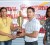 Proprietor of Trophy Stall, Devi Sunich, (left) on Tuesday presented the men’s overall winner’s trophy to Treasurer of the GABBFF and owner of Fitness Express, Jamie McDonald, while GABBFF committee member Morissa Oscar looks on. (Orlando Charles photo)