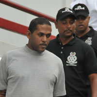 Marlon King (left) being led away (Trinidad Express photo)