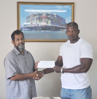 Managing Director of Mohammed’s Enterprise and the City Mall Nazar Mohamed (Left) hands over the cheque to HRC’s Sponsorship and Finance Officer Dexter Garnett.           