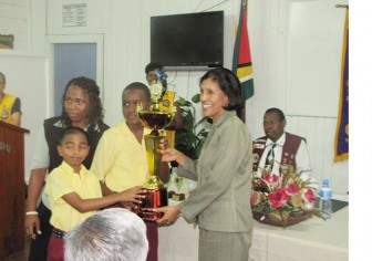 First Lady Deolatchmee Ramotar presents the President’s Trophy to students of the Amelia’s Ward Primary School, which clinched the award for ‘Best School’ at the recent NCERD/Demerara Lioness Club reading competition. 