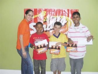 The winners of the Smalta Kite Flying Competition pose with their prizes. In photo with a representative from Smalta are (from left) Alex Persaud, Noel Moraglia and Andrew Ramphaul.