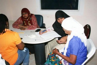  A representative of the Masjid An-Najm holds an elderly woman’s hand as she assists her with access treatment when the Health Ministry hosted an outreach exercise there on Saturday. 