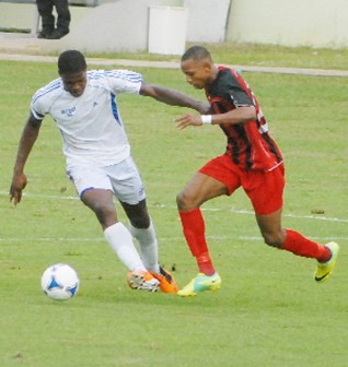 Inter Moengotapoe striker Stefano Ryssel, right, battling for possession with one of Milerock’s defenders during action in yesterday’s Caribbean Football Union (CFU) Club Championships game at the Providence National Stadium. (Orlando Charles photo)