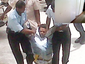 Denzel Kitsu being lifted into the courtyard by policemen after he was remanded. Inset are the indentations and blood spatters that were left after Kitsu hitting his head against the courtroom wall. 