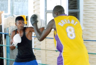 Charlton Skeete attacking the pads of trainer James Walcott during his training session yesterday at the Harpy Eagles gym. (Orlando Charles photo)