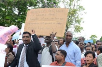 Minister Irfaan Ali (left) and some of the protesters today outside of Parliament