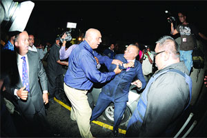 Assistant Superintendent Ajith Persad of the Port of Spain CID struggles to arrest Crime Watch host Ian Alleyne last night at Express House carpark in Port of Spain. Alleyne, it was said, was wanted for questioning in an alleged criminal matter in relation to a video showing the rape of a minor on Crime Watch last October.(Trinidad Express photo)