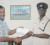 Colin Boyce receives cheque from Nazar Mohammed at the proprietor’s head office.
