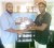 Insaf Jumrally (left) presents a cash donation to Caribbean Boxing Federation (CABOFE) welterweight champion Simeon ‘Candy Man’ Hardy yesterday at Mohamed’s Enterprise on Lombard Street.  Jumrally made the presentation on behalf of Mohamed’s Enterprise CEO Nazar Mohamed, to assist with Hardy’s out-of-ring expenses. Hardy is scheduled to be in action on June 1 and June 29 at the Cliff Anderson Sports Hall. 